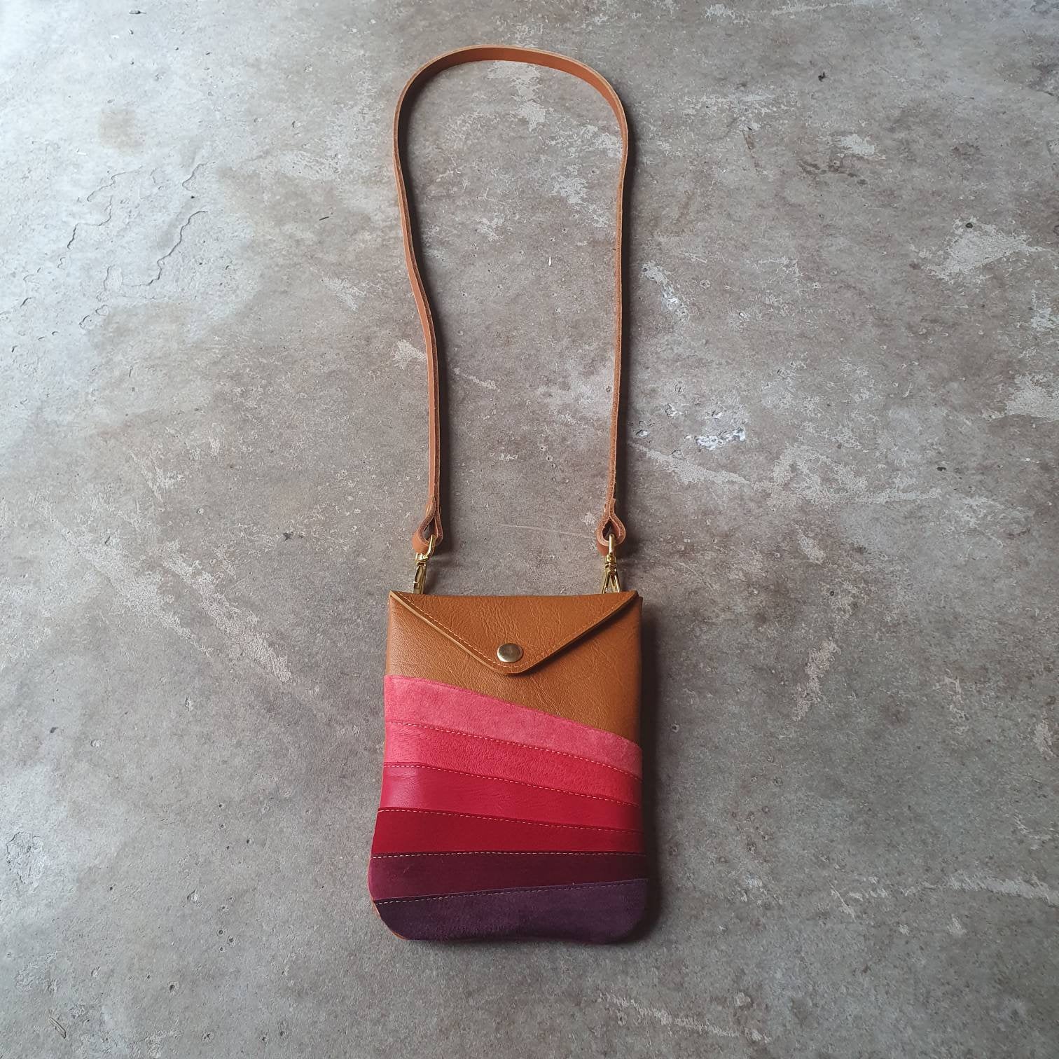 Tan leather handmade handbag with multiple shades of red stripes