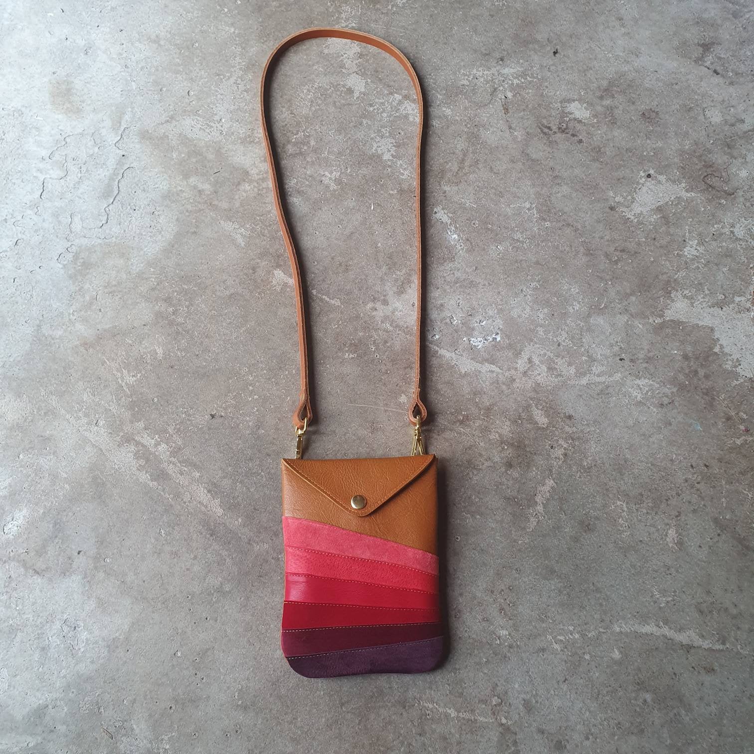 Tan leather handmade handbag with multiple shades of red stripes