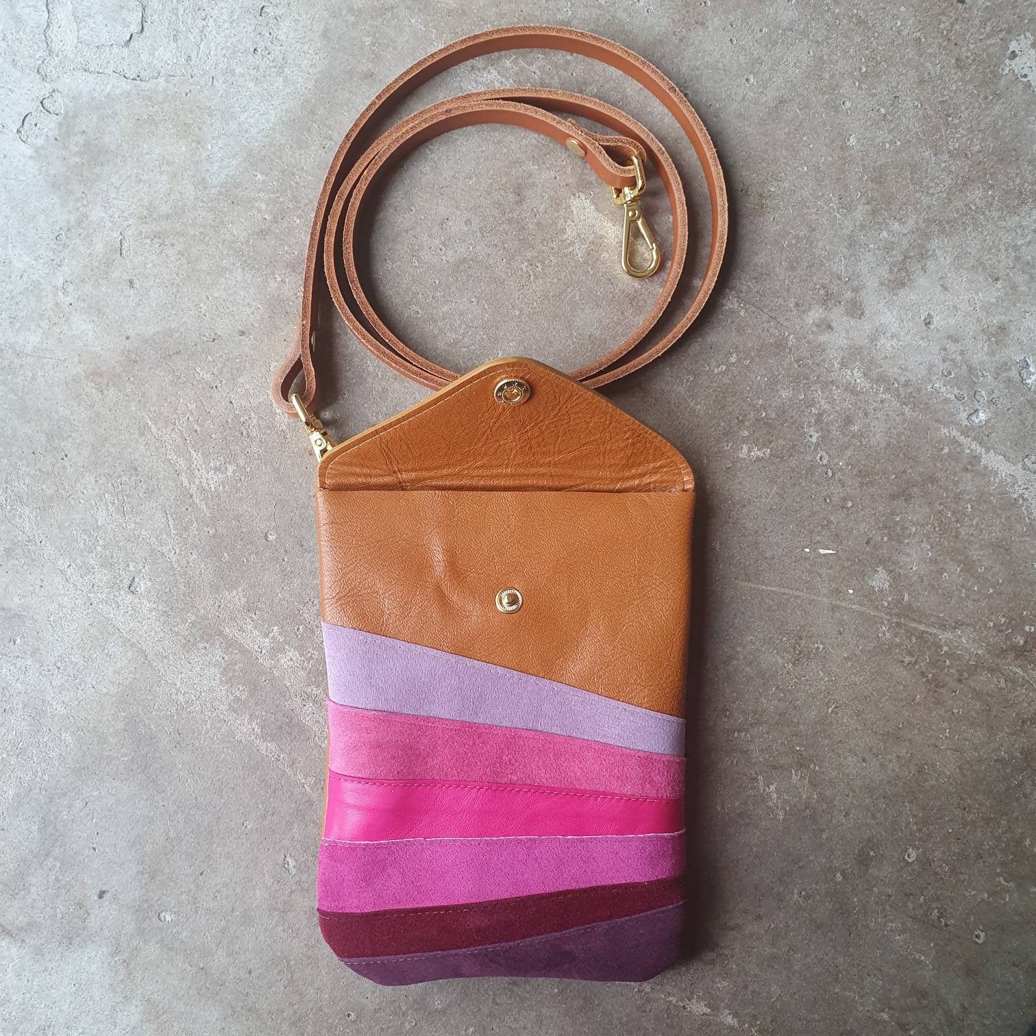 Tan leather crossbody handmade handbag with multiple shades of pink stripes