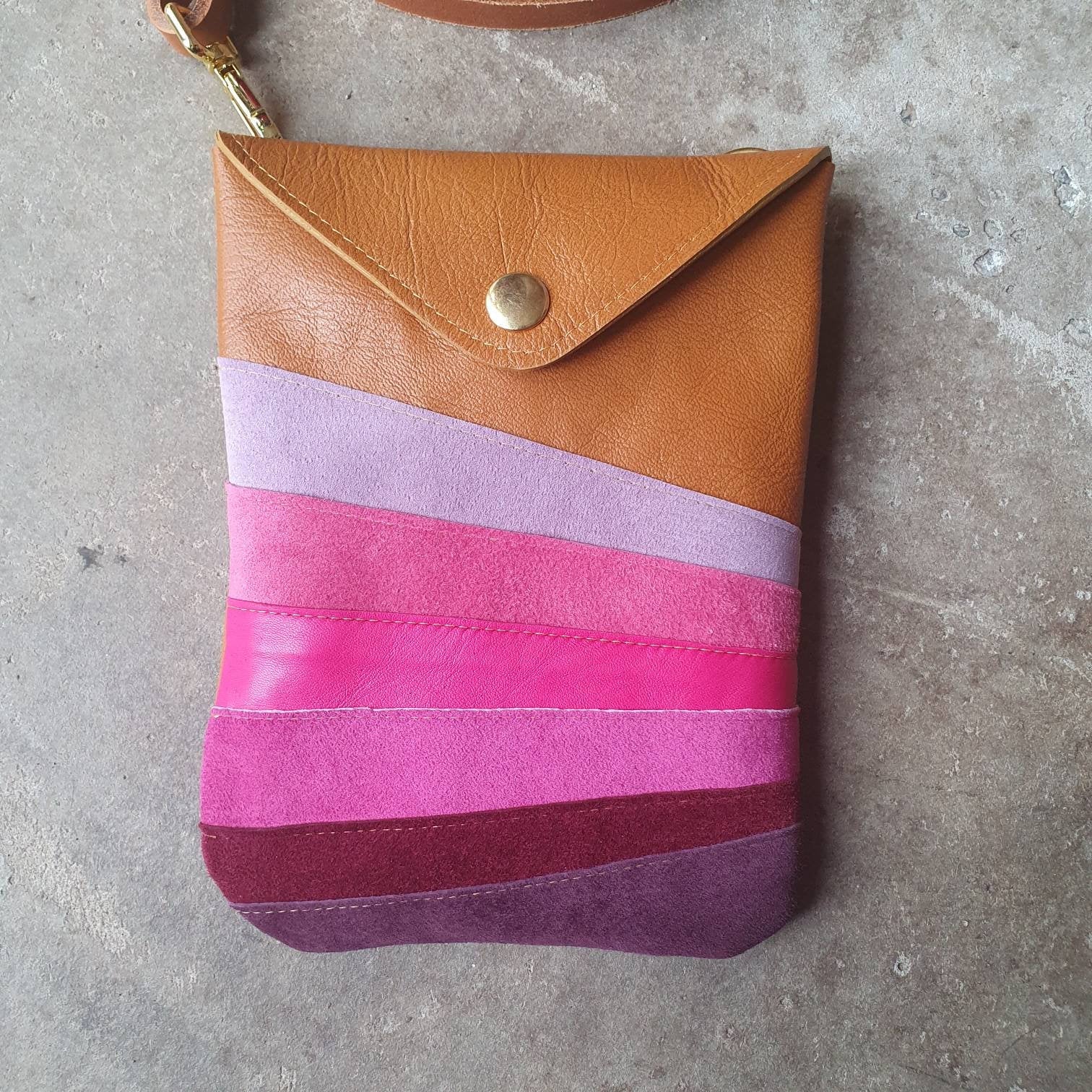 Tan leather crossbody handmade handbag with multiple shades of pink stripes