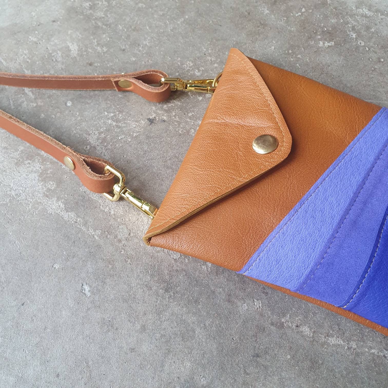 Tan leather handmade handbag with multiple shades of blue stripes