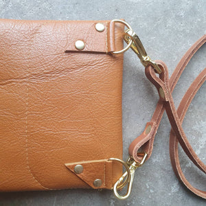 Tan leather handmade handbag with multiple shades of blue stripes