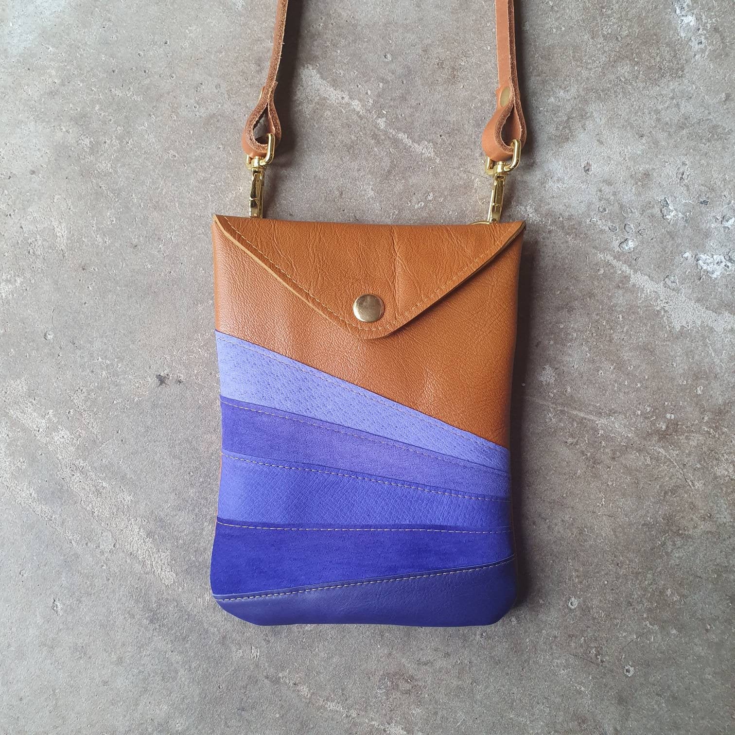 Tan leather handmade handbag with multiple shades of blue stripes