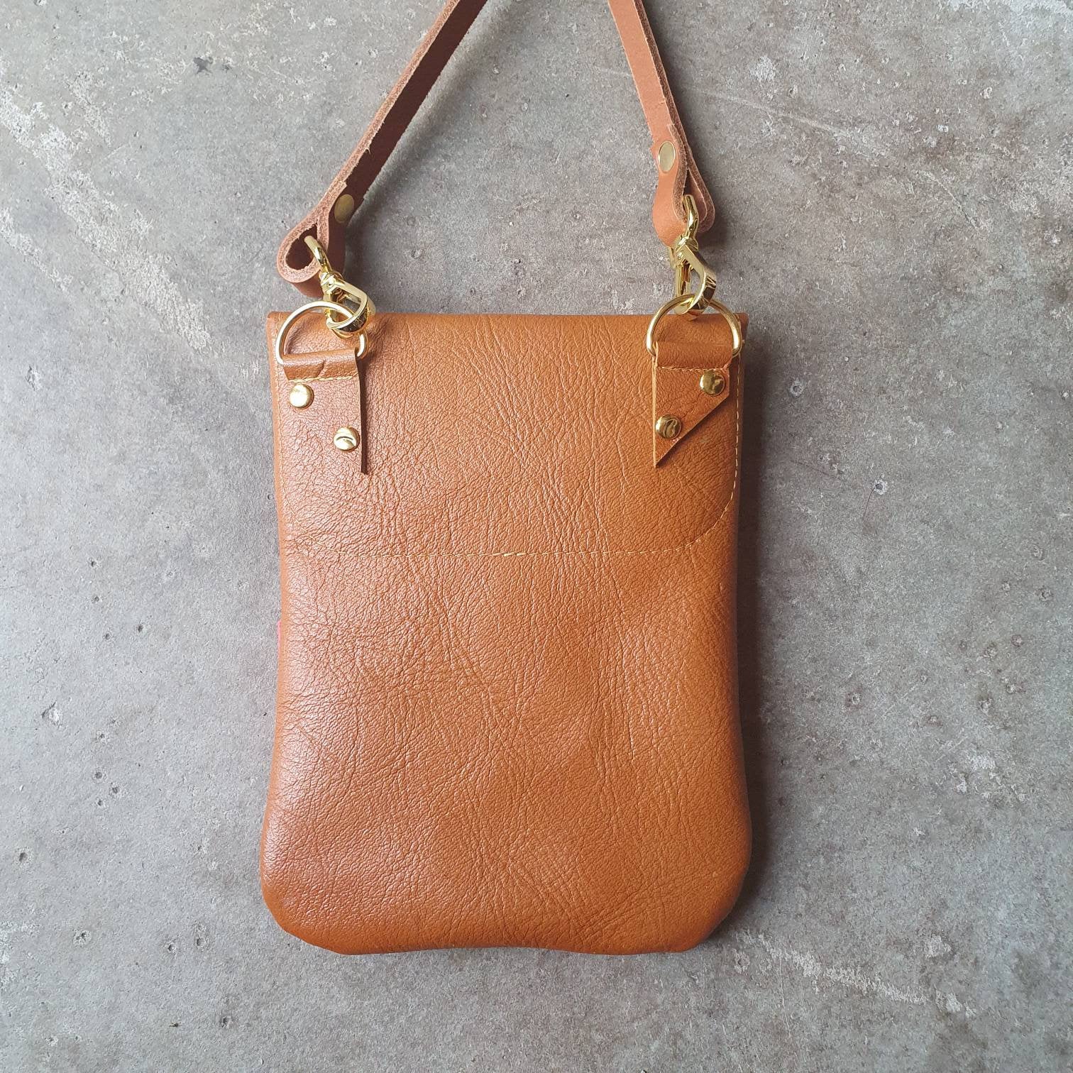 Tan leather handmade handbag with multiple shades of red stripes