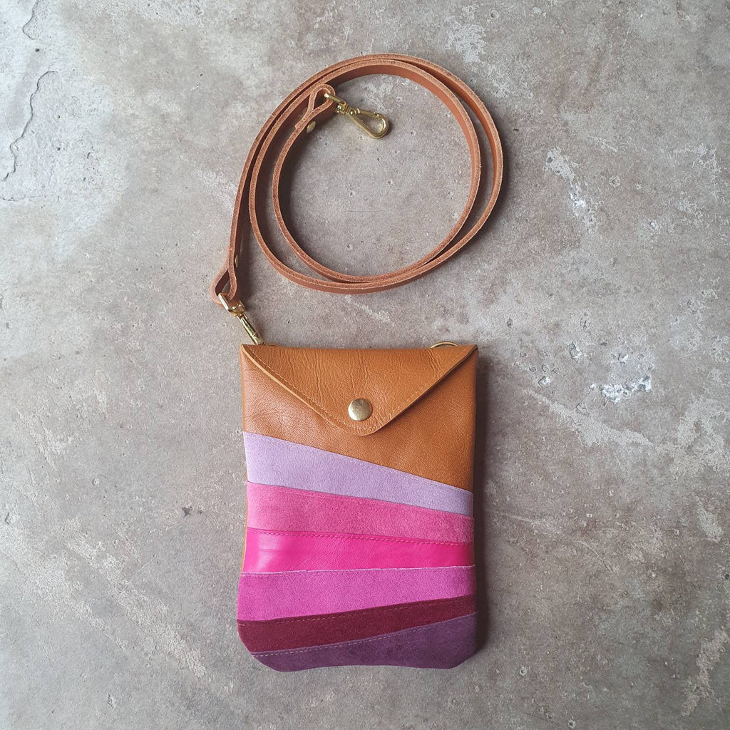 Tan leather crossbody handmade handbag with multiple shades of pink stripes