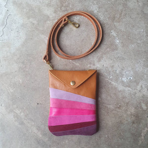 Tan leather crossbody handmade handbag with multiple shades of pink stripes