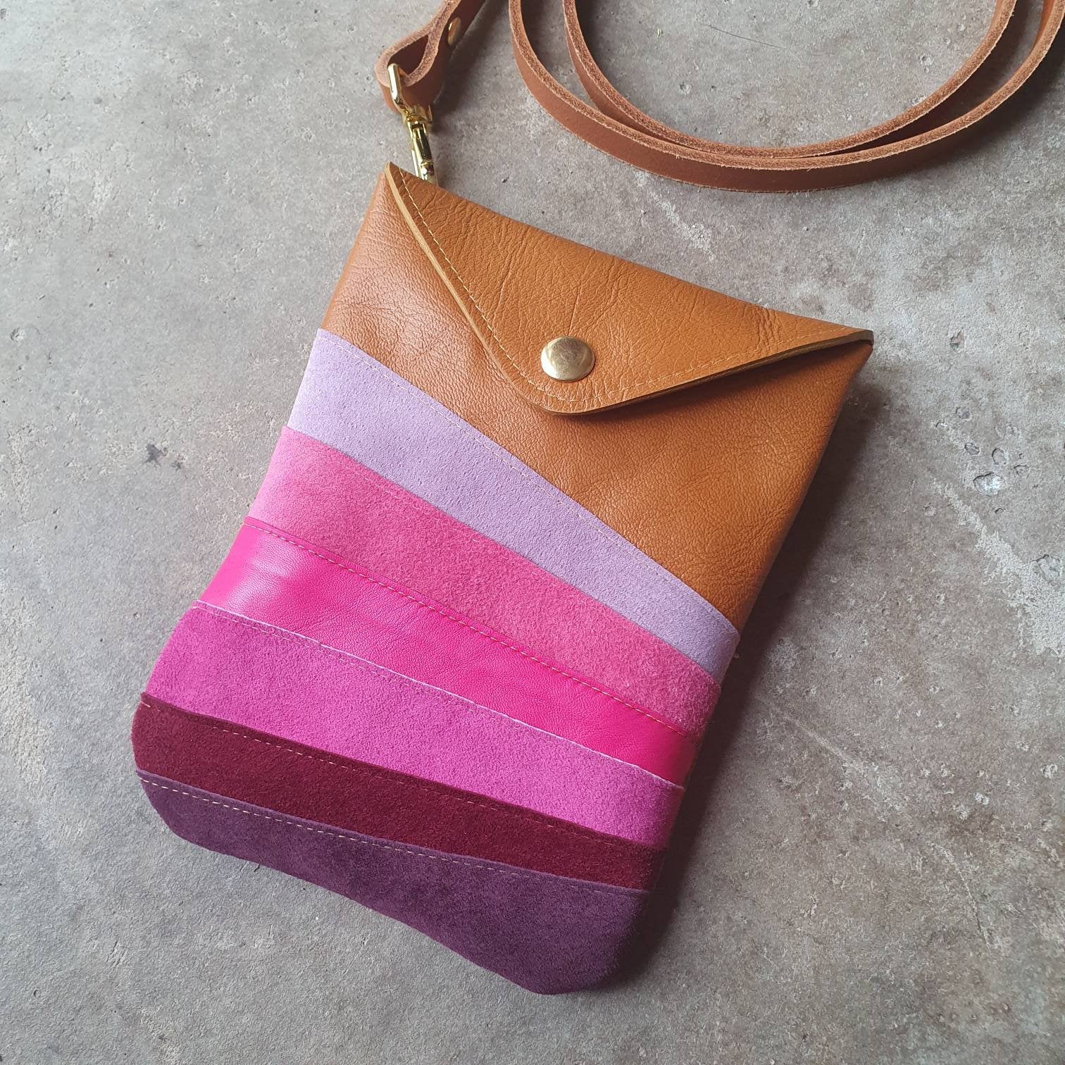 Tan leather crossbody handmade handbag with multiple shades of pink stripes