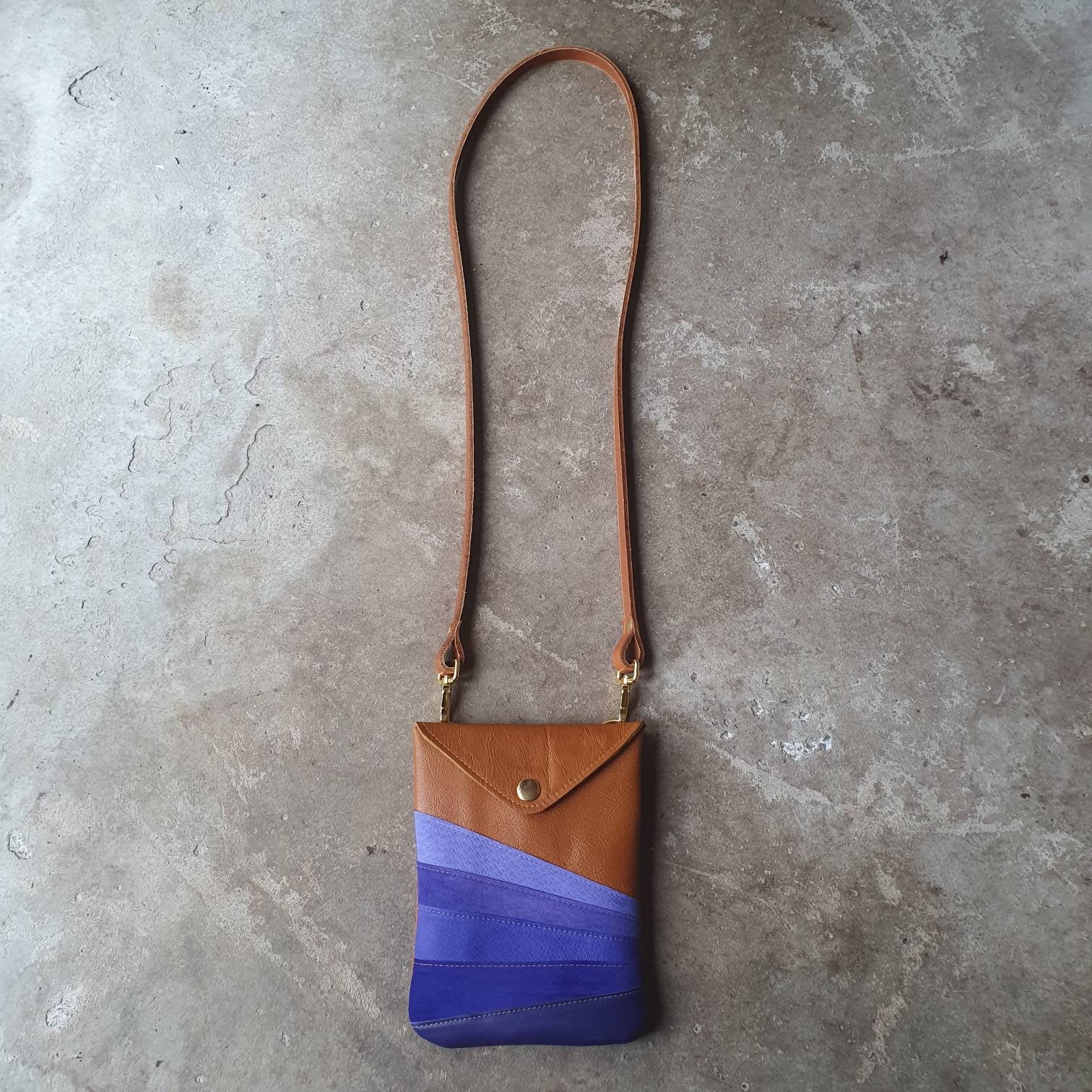 Tan leather handmade handbag with multiple shades of blue stripes