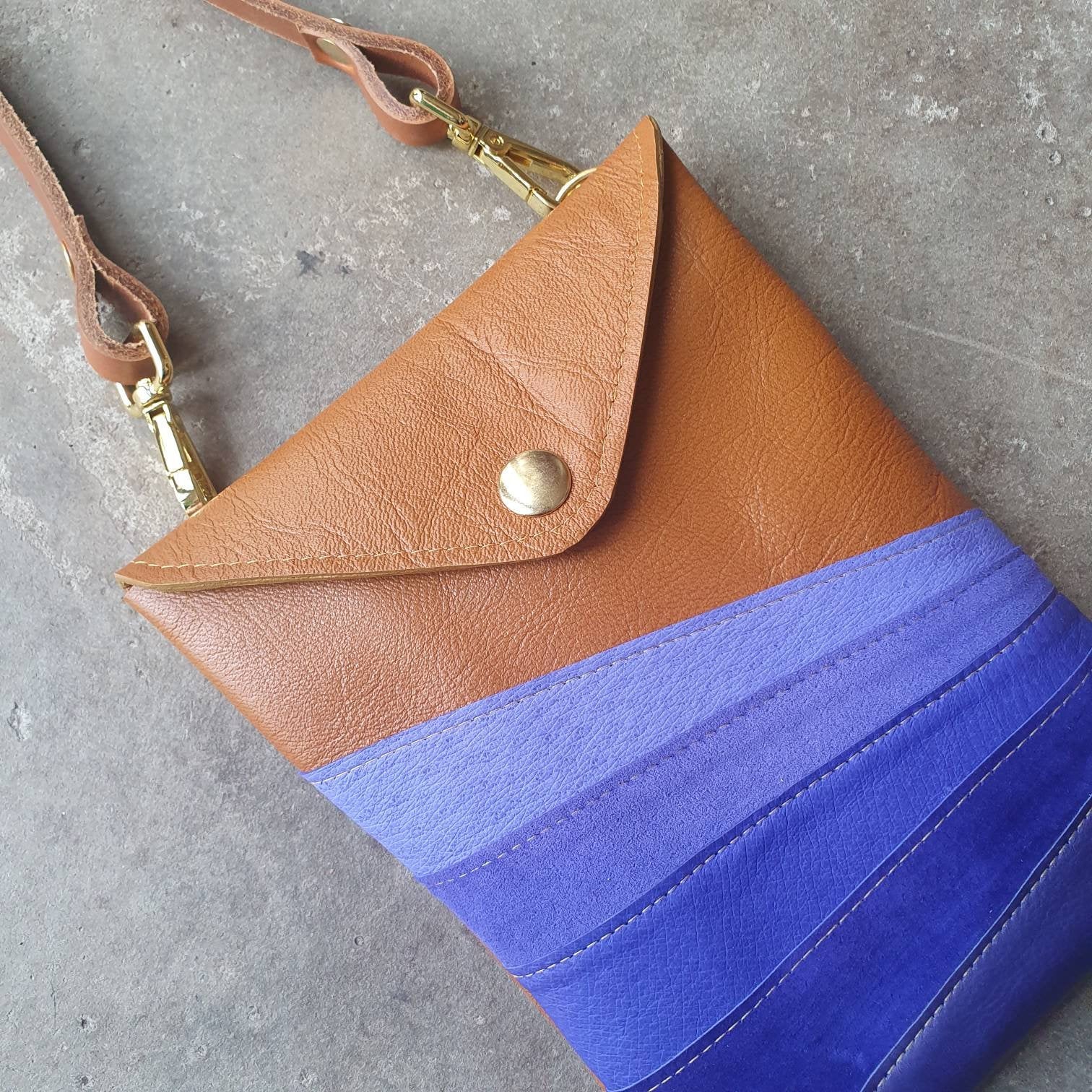 Tan leather handmade handbag with multiple shades of blue stripes