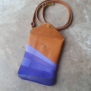 Tan leather handmade handbag with multiple shades of blue stripes