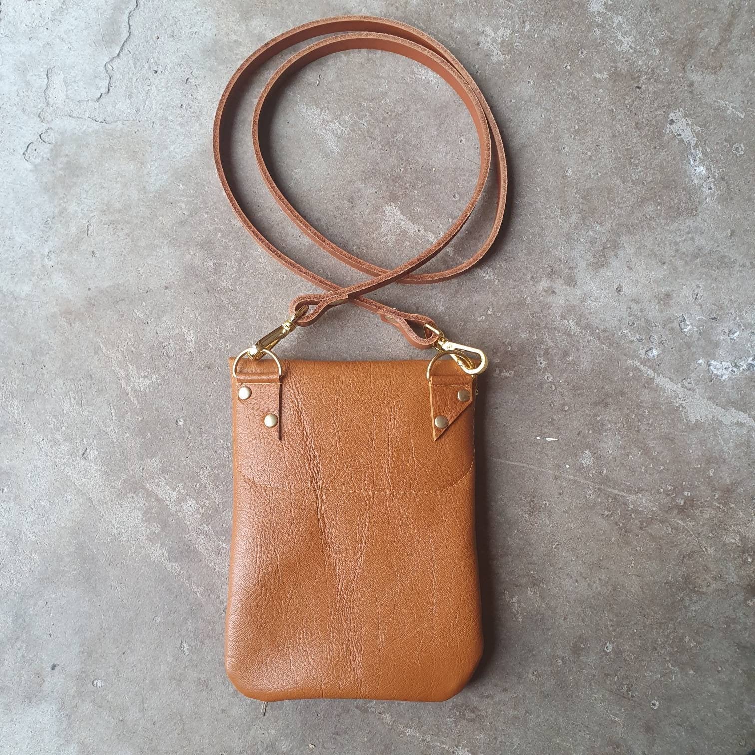 Tan leather handmade handbag with multiple shades of blue stripes