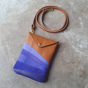 Tan leather handmade handbag with multiple shades of blue stripes